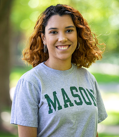 Schar School student Veronica Mata smiles at the camera in a Mason tee shirt.