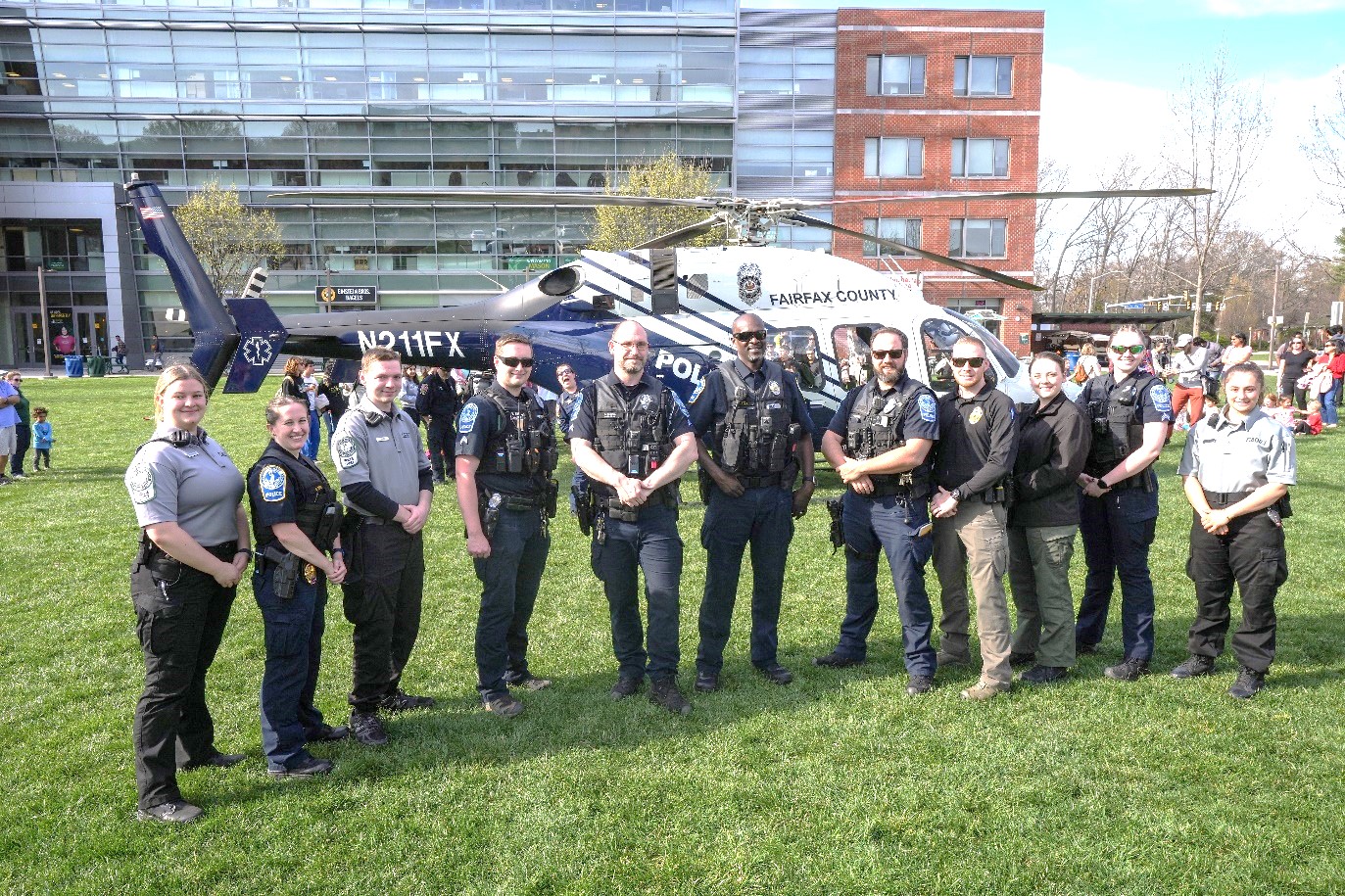 A group of police officers stand in front of a helicopter