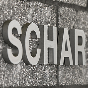 A photo of the word SCHAR on a concrete block wall.