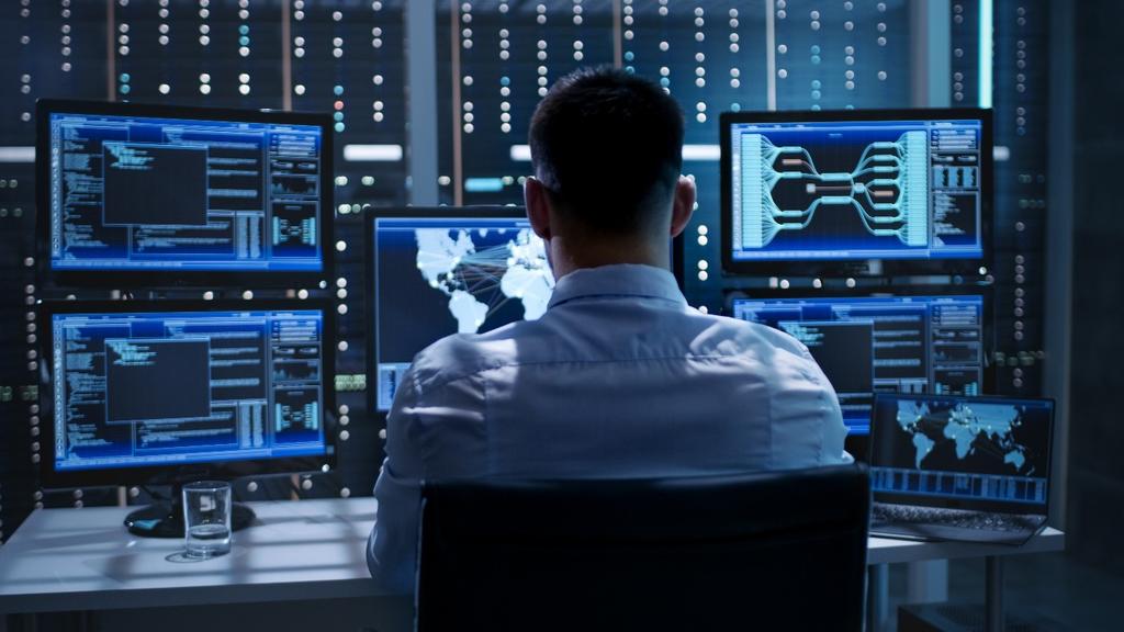 Photo of a person working on a computer with multiple monitors