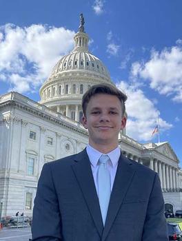 Matthew Glaubke smiles at the camera as he stands in front of the U.S. Capitol in Washington, D.C.